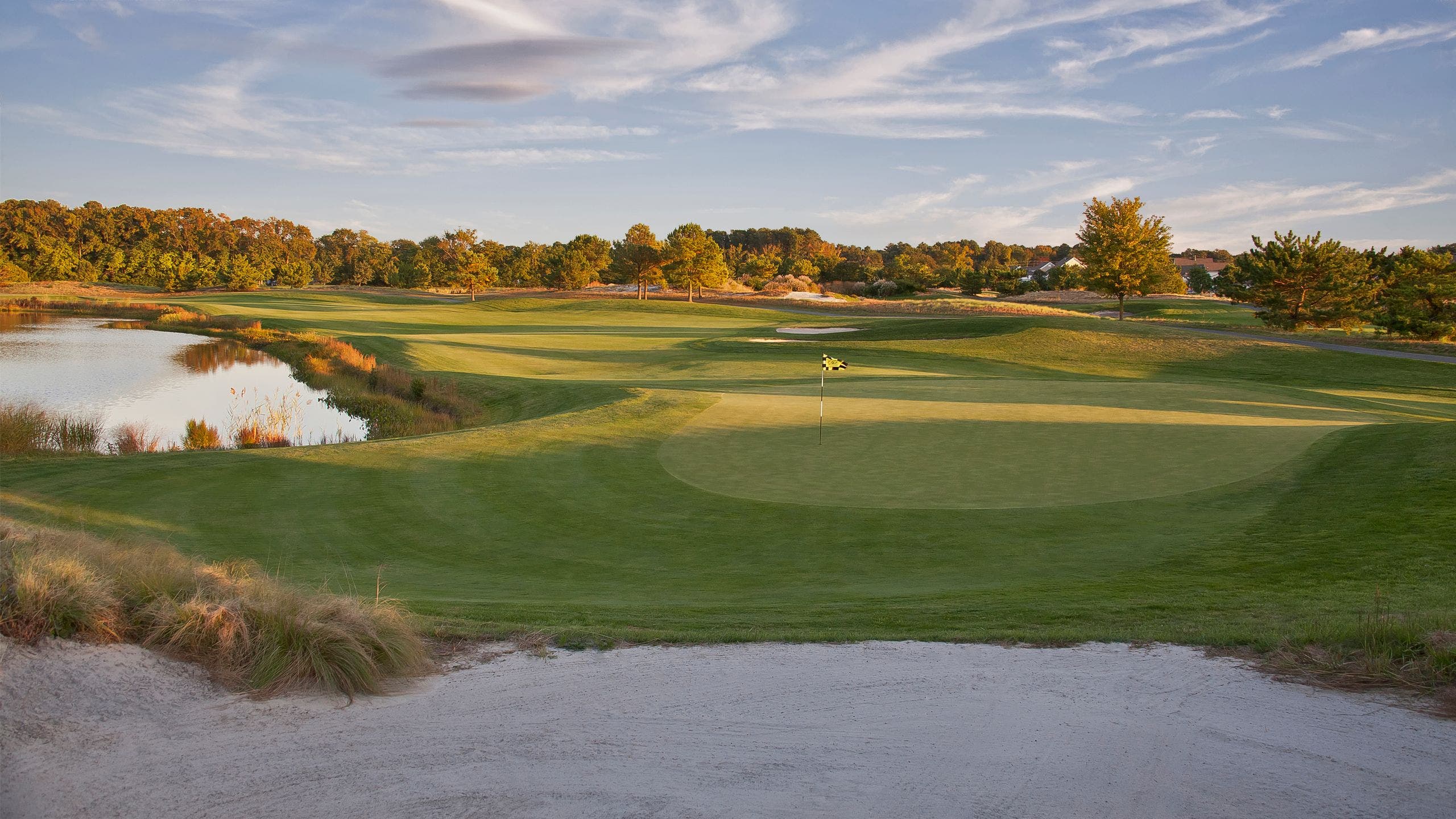 Landscape putting greens and fairway photo of the Bear Trap Dunes Golf Club golf course