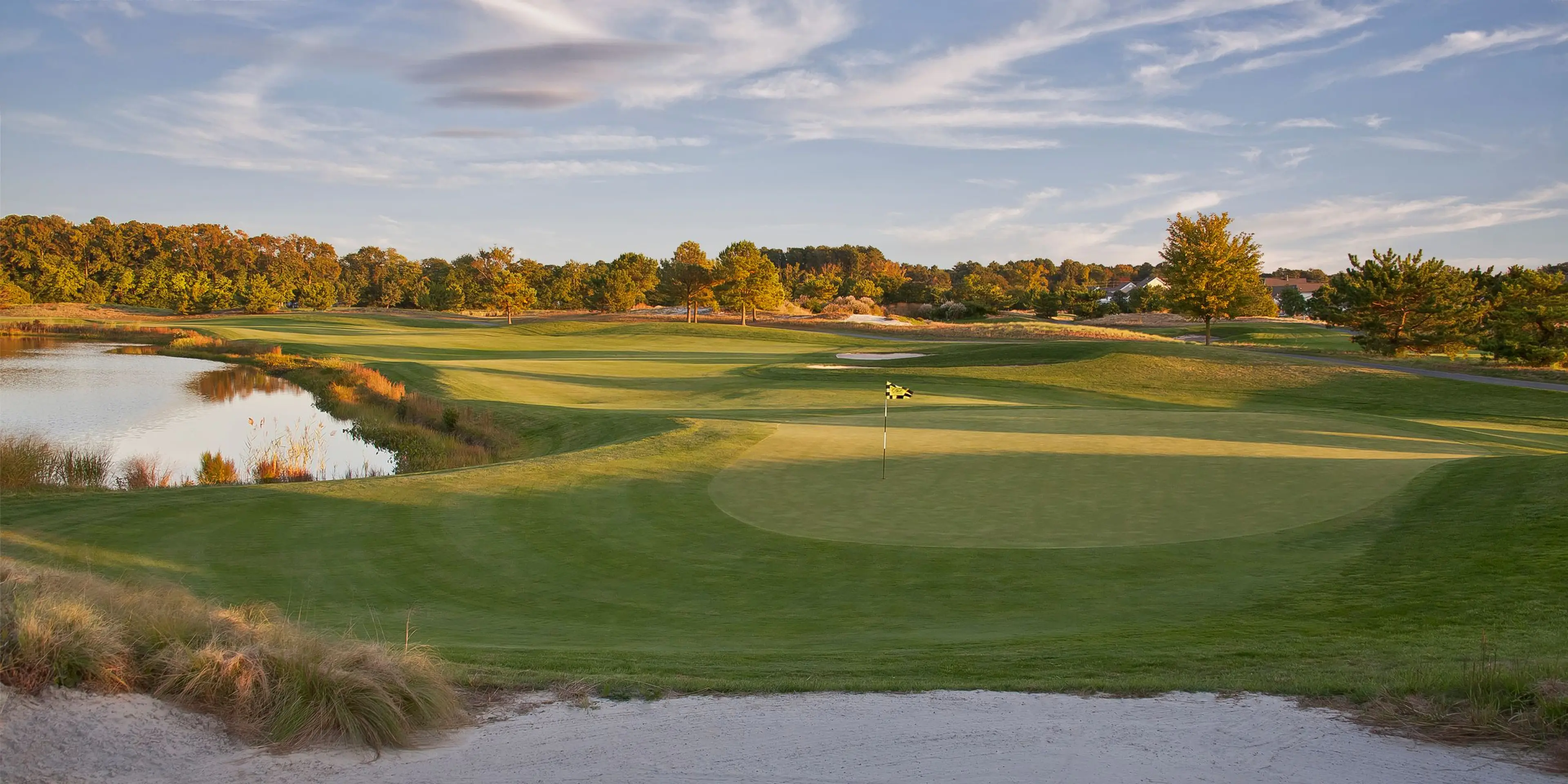 Landscape putting greens and fairway photo of the Bear Trap Dunes Golf Club golf course