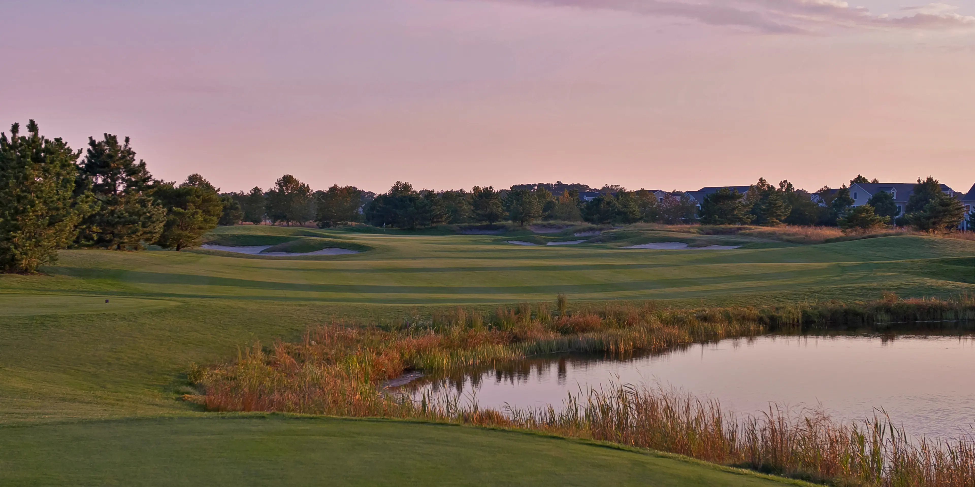Landscape putting greens and fairway photo of the Bear Trap Dunes Golf Club golf course