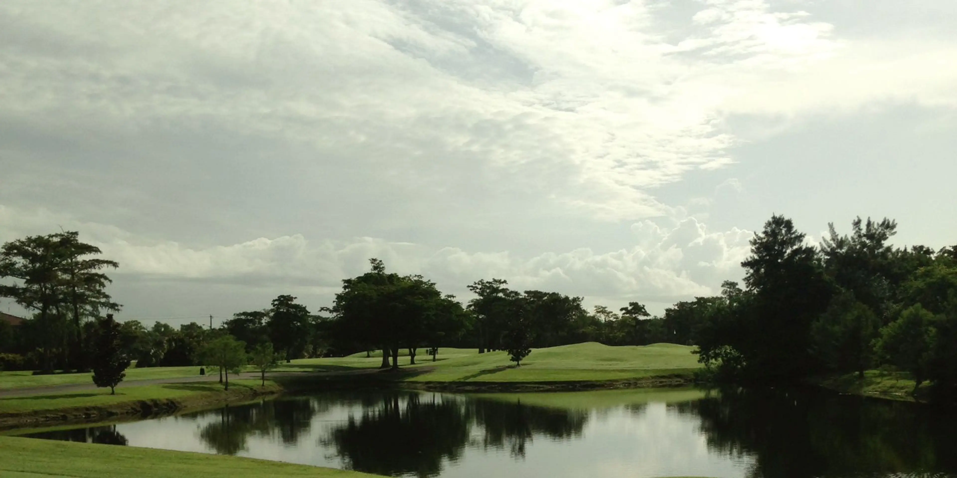 Landscape putting greens and fairway photo of the Colony West Country Club golf course