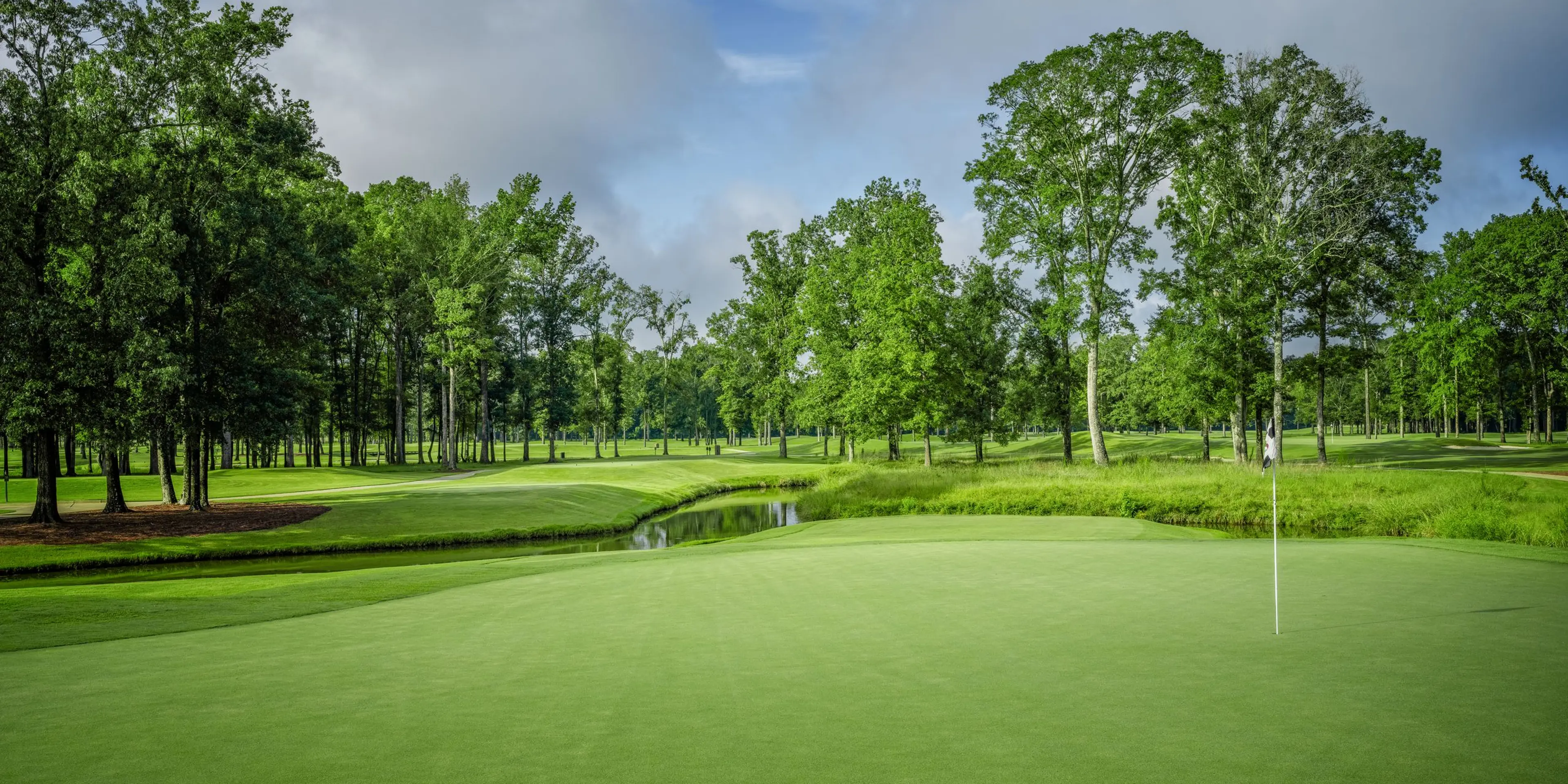 Landscape putting greens and fairway photo of the The Refuge Golf Course golf course
