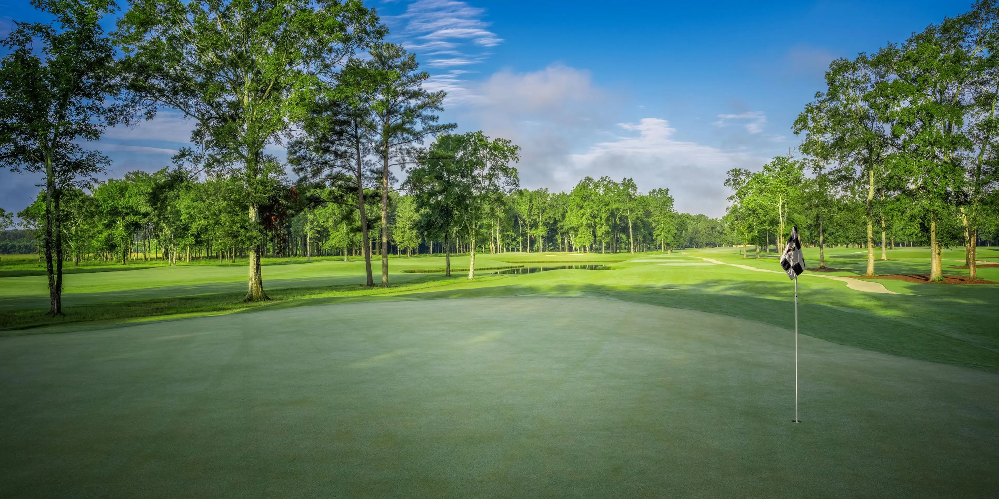 Landscape putting greens and fairway photo of the The Refuge Golf Course golf course